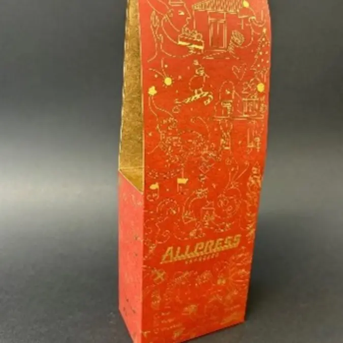 Red and gold Allpress packaging box featuring festive illustrations like Santa, gifts, and a Christmas tree, designed for seasonal products and holiday gifting.